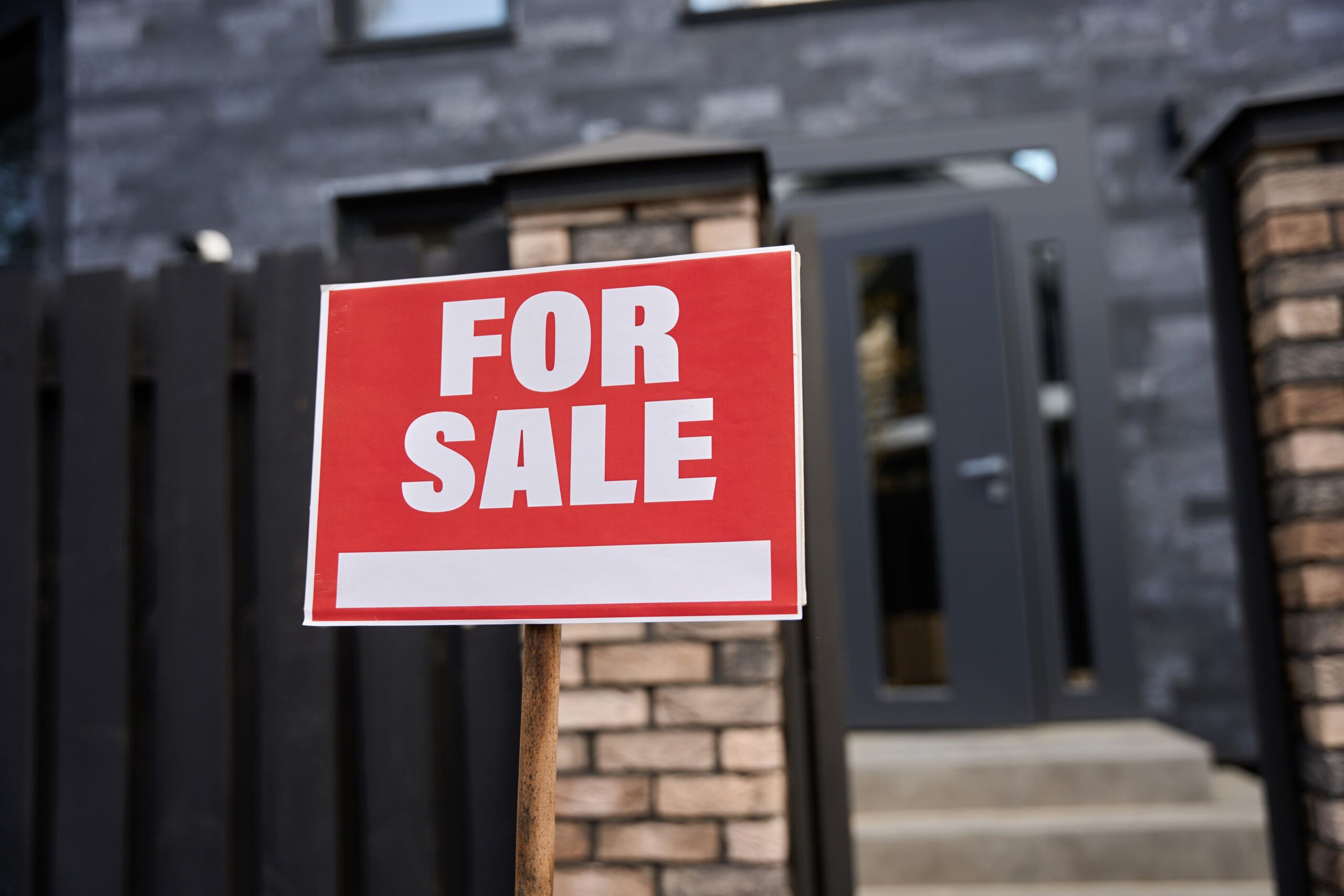 House with a for sale sign representing an as-is home sale